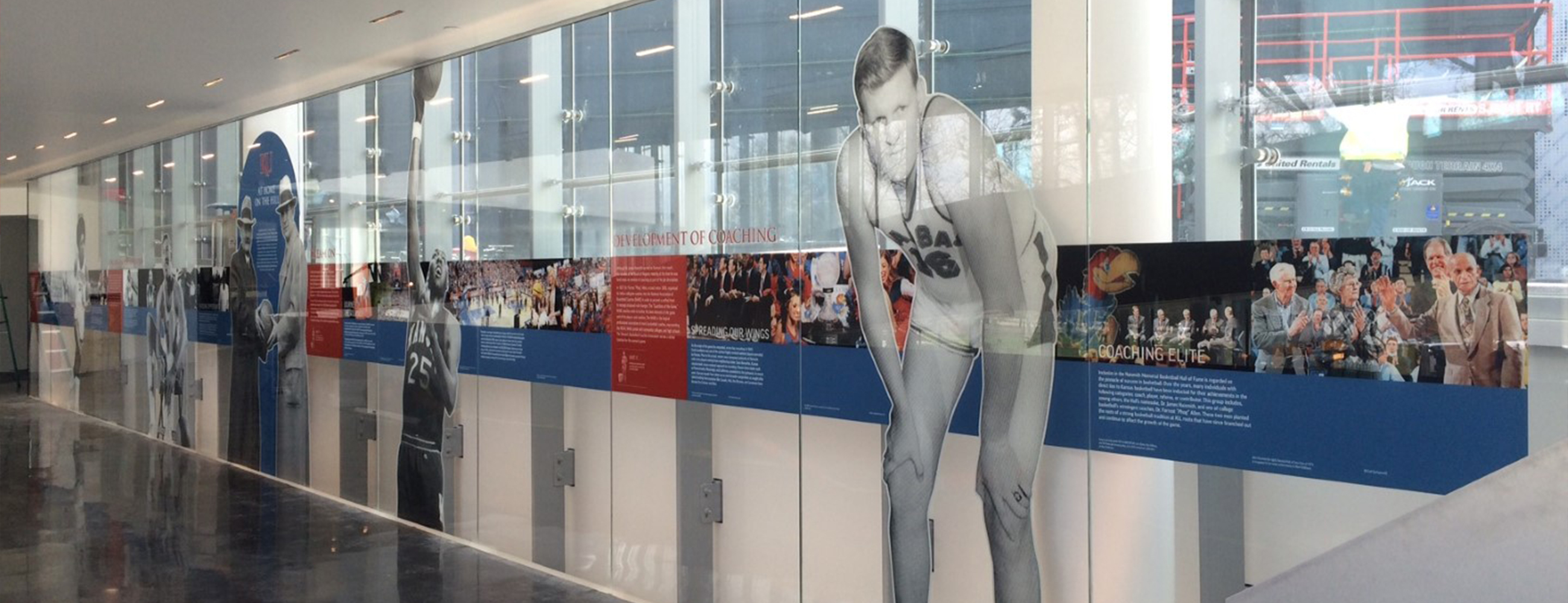 Inside Kansas University, a view of the glass mural depicting images and copy from the history of basketball.