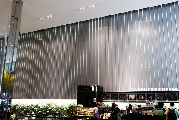 Inside BlackRock's office tower, a view of starbucks cafe and behind, the oversize laminate panels