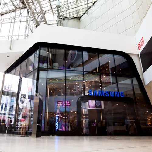 Interior mall view of all-glass façade for Samsung consists of oversized/jumbo, insulated, Low-E, glass units with complex, compound curves fabricated by AGNORA